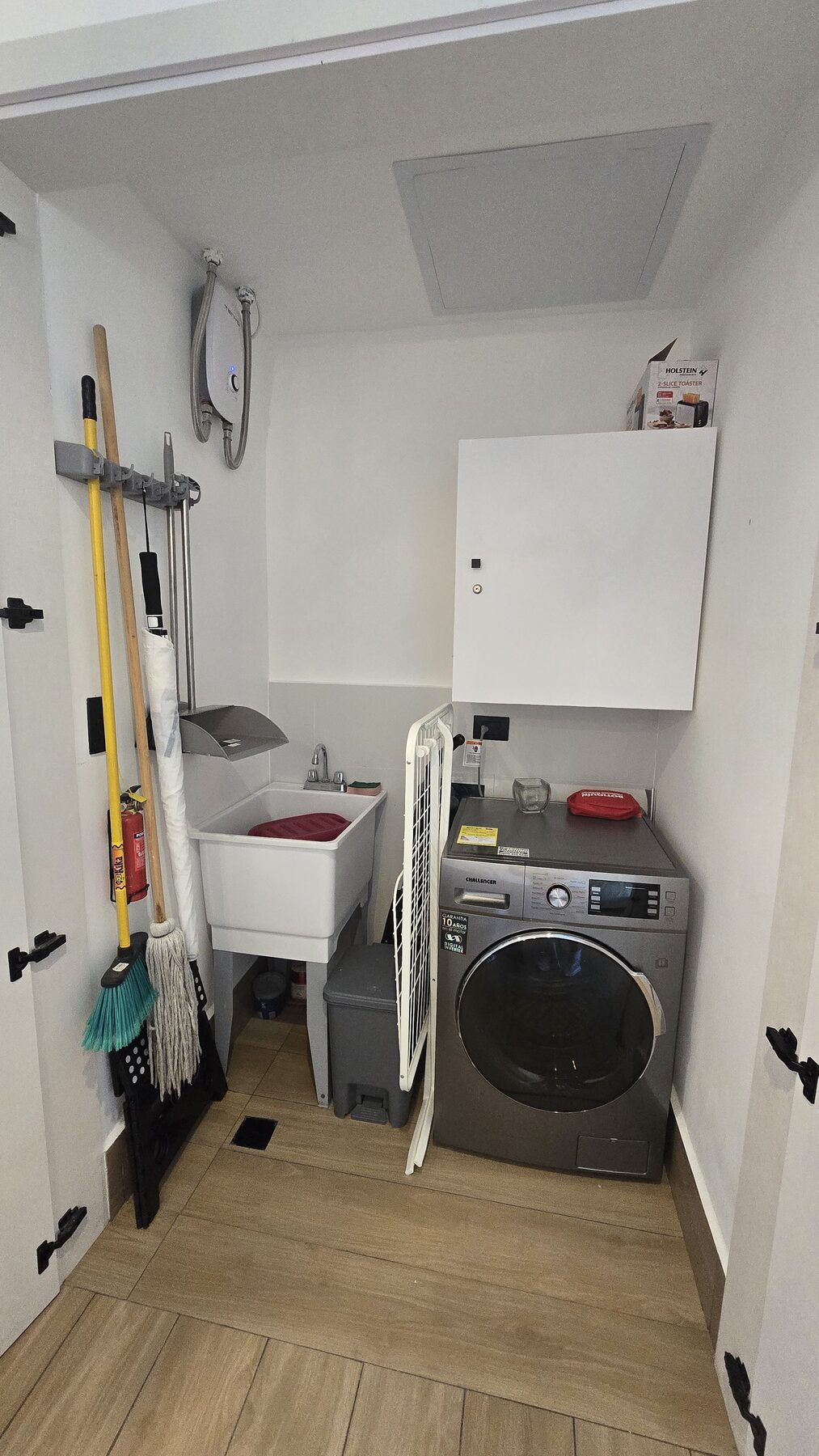 In-unit laundry room with washer, utility sink and drying rack