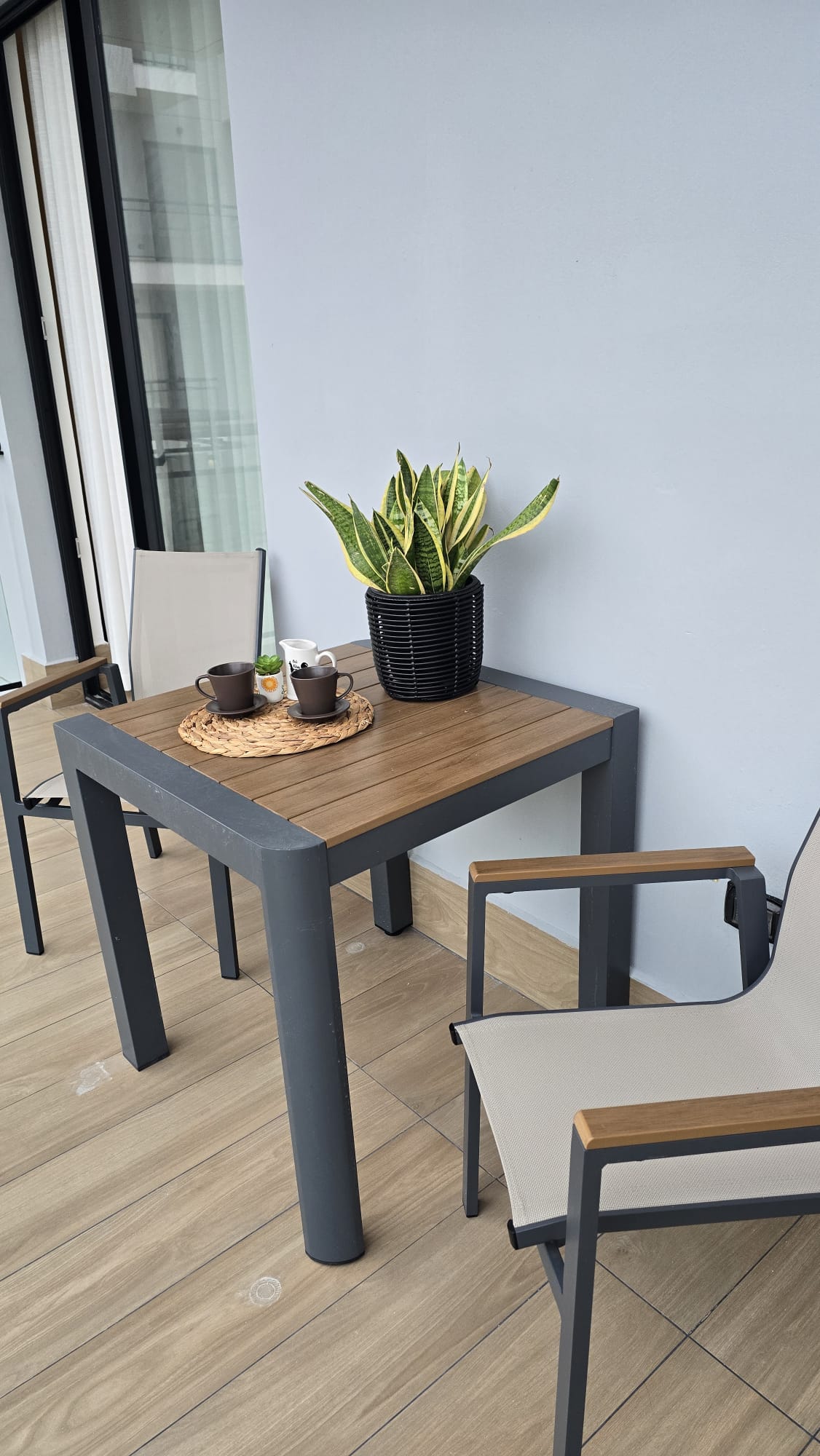 Private balcony with morning coffee setup, tropical plant and garden views